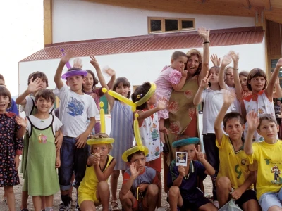 A young Anita Roddick with a group of children in Kosovo