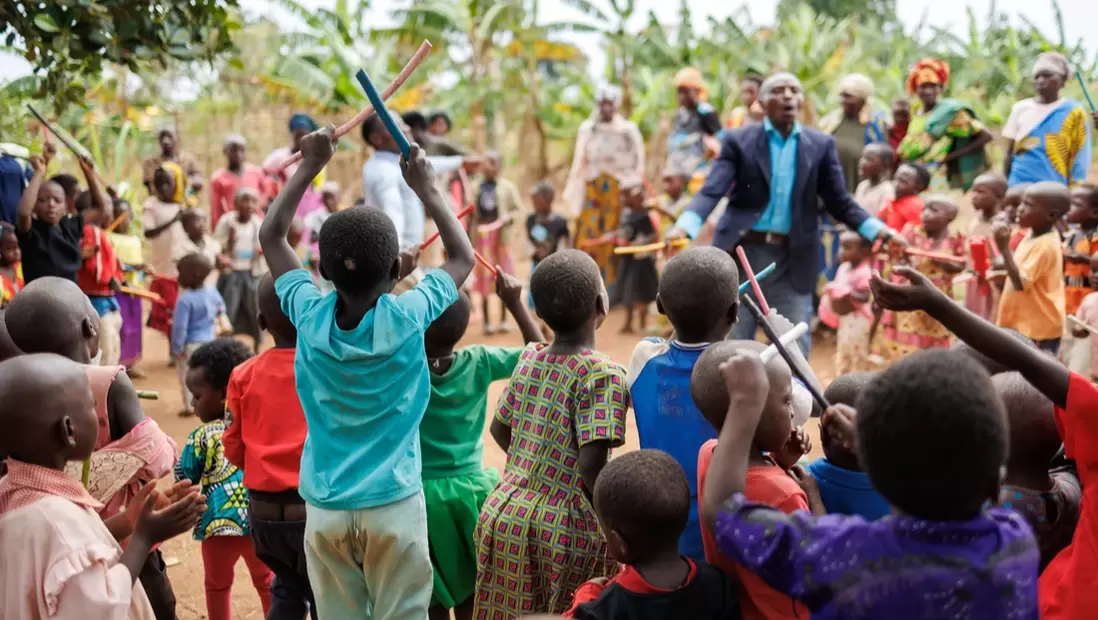 Children singing and dancing during a cluster lesson in Uganda