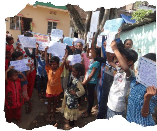 Group of Indian children from a children on the edge school stood together outside in their community campaigning for their rights by holding up placards with various slogans on. 