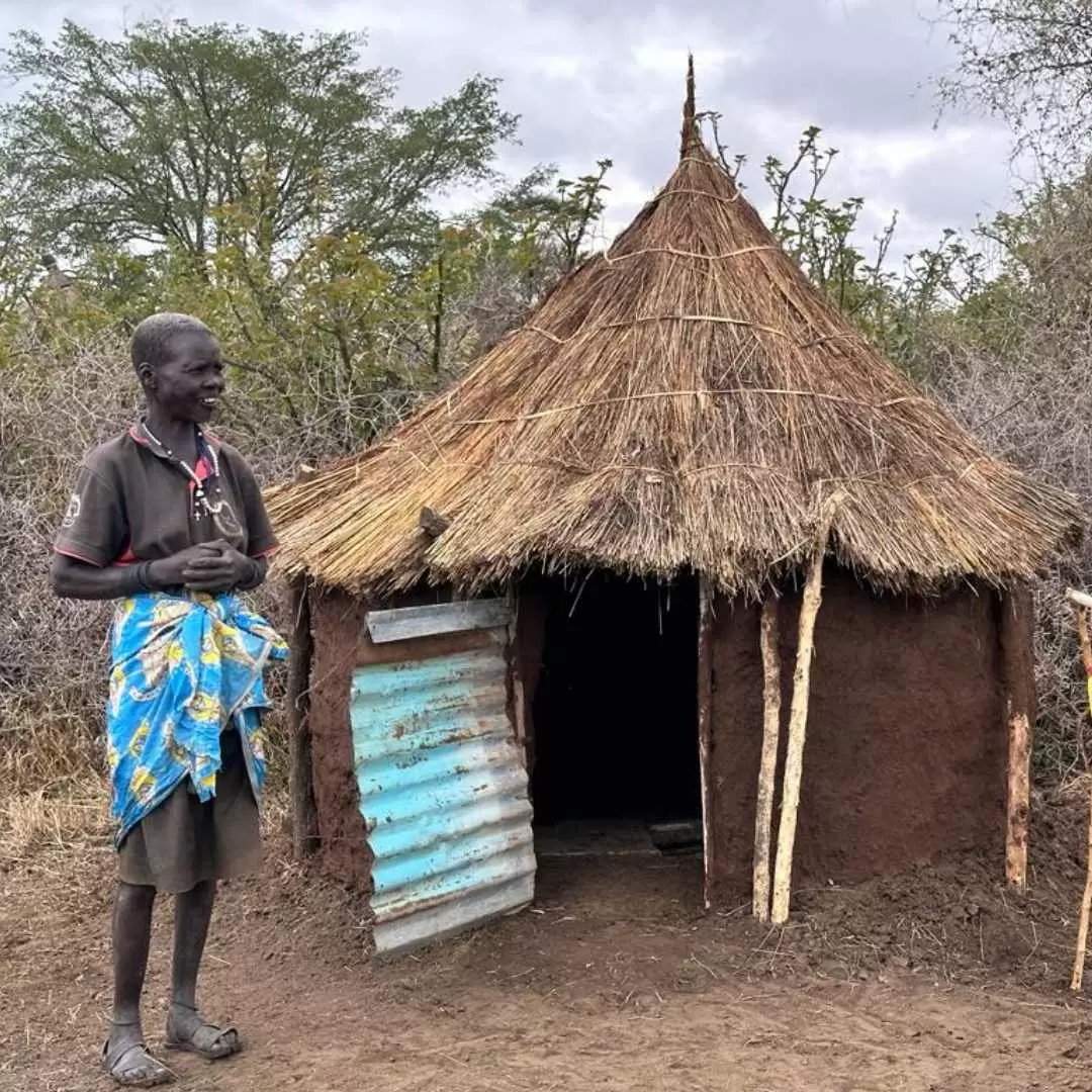 A community member standing outside one of the newly built pit latrines in Karamoja