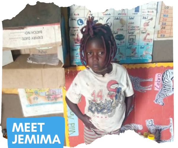 Four year old Congolese girl with purple dreadlocks is standing in front of a board in her classroom with pictures of animals on it, with their names. Some text superimposed on the image reads 'Meet Jemima'
