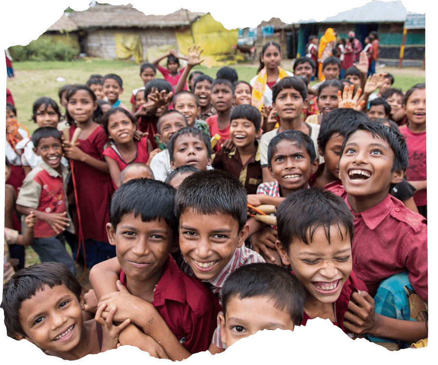 Large group of children from one of our schools in Bangladesh, they are crowded together smiling and laughing.