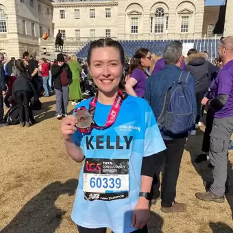 Kelly holding her medal after completing the London Marathon