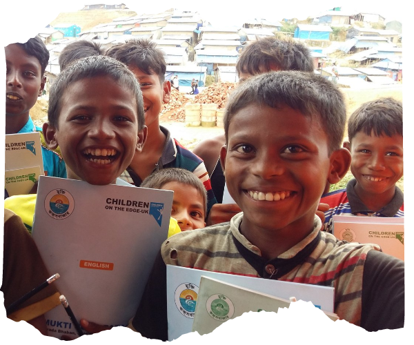 Group of Rohingya boys holding Children old the Edge school textbooks and laughing and smiling. The background shows a long hilly landscape packed with makeshift shelters. 