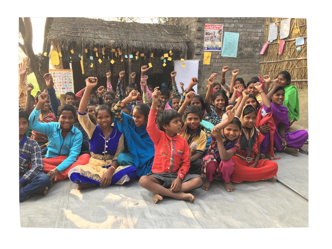 A group of Dalit children sat cross legged on the floor outside their classroom. 
