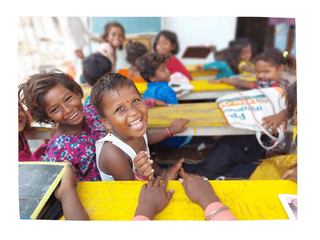 Two Dalit children smiling in their classroom