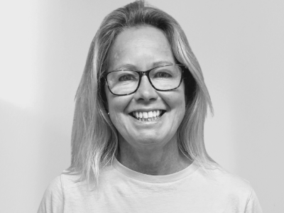 Woman with blonde hair and glasses smiling
