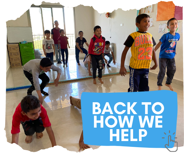 A simple classroom with 10 young boys aged around 10 and their male teacher. The children are in the middle of a PE class and are jumping in the air and smiling. You can click on the image to go back to page detailing how we help support children in Lebanon