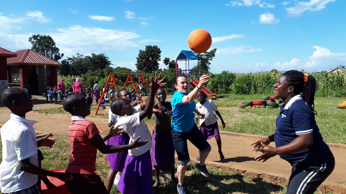 Children in Uganda jumping and playing with a basket ball