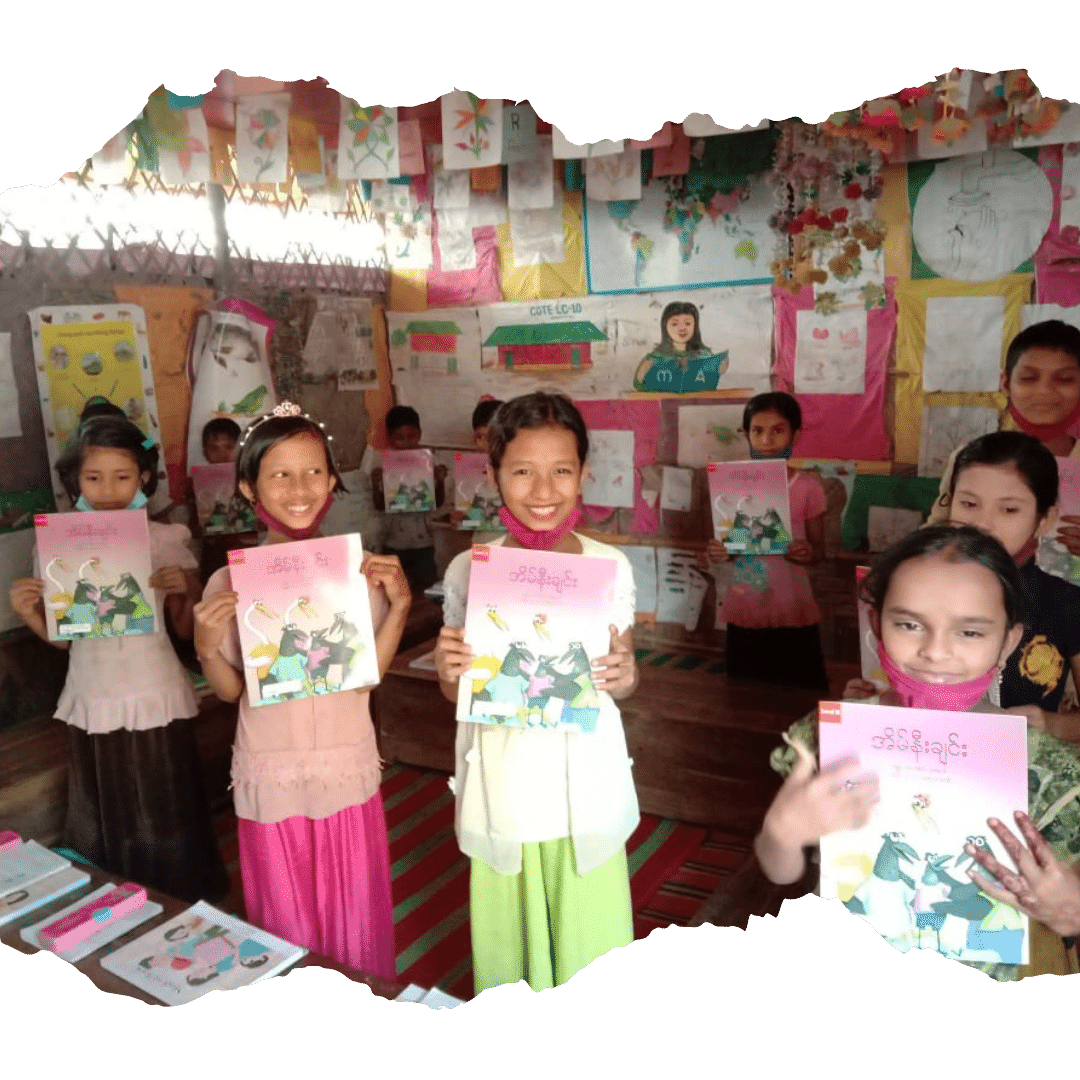 Children in a classroom in Kutupalong holding up school books