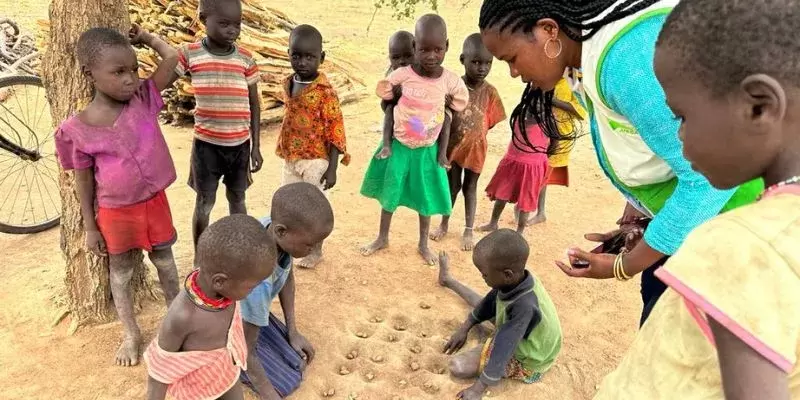 Children in Napak, Karamoja playing a game with stones in the dirt