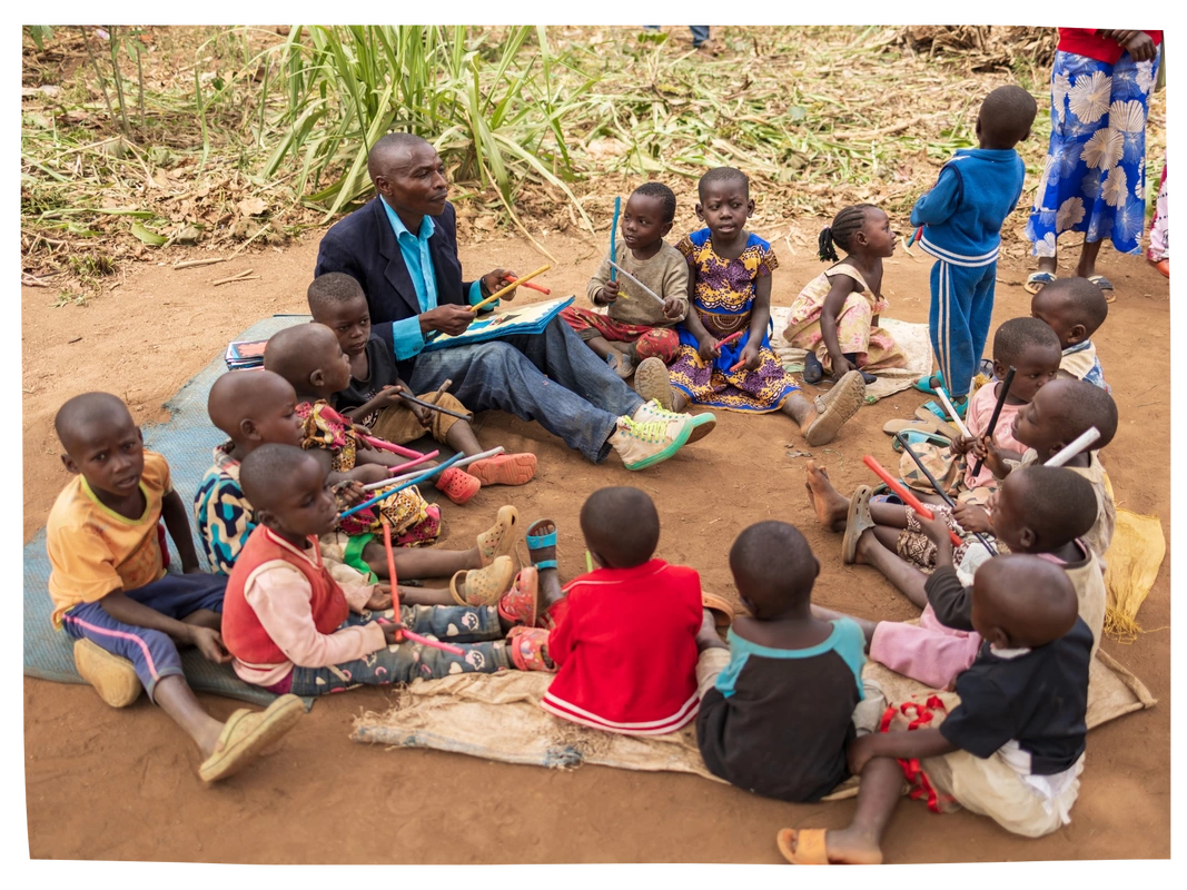A cluster lesson with Congolese children playing with coloured sticks