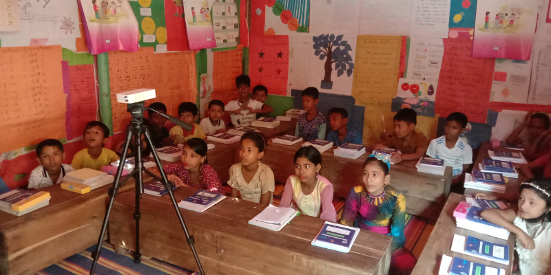 Children in a classroom watching a digital lesson on a projector