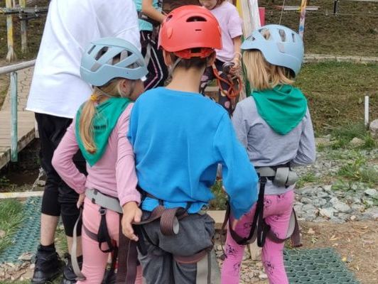 Three children pictured from behind about to go climbing at an activity centre