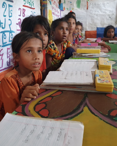 Rohingya children gaze in wonder at the digital screen in their classroom in Bangladesh