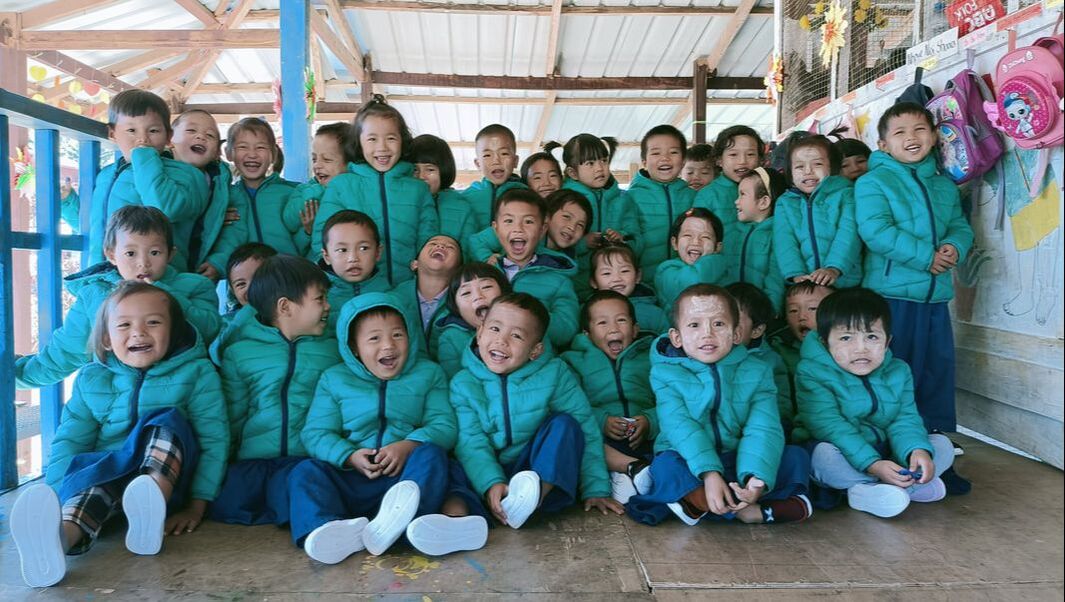 Children displaced by conflict in Kachin, Myanmar are happy to receive new warm coats.