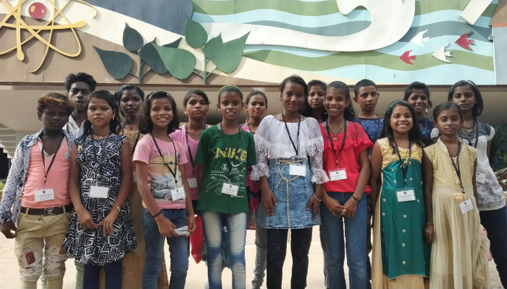 A group of Indian teens are stood together with lanyards around their necks smiling, they are members of the Child Parliaments we support in India