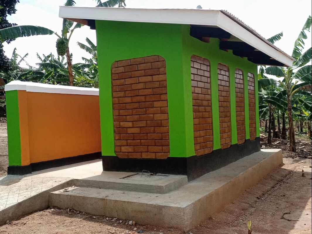 A brand new toilet block built with bricks on a concrete base. The building has 4 cubicles and is clean and bright.