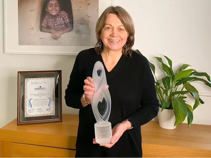Rachel Bentley holding a glass trophy from the Harmony Foundation 