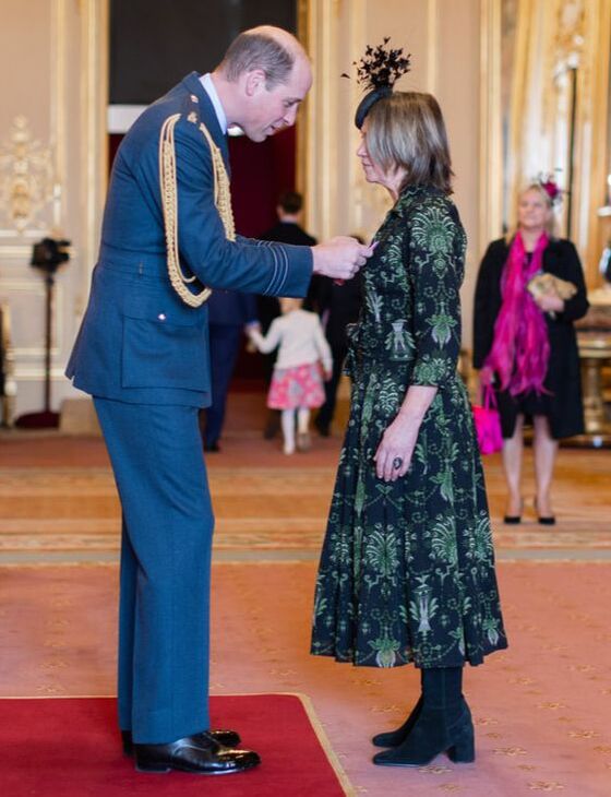Prince William pinnning OBE award to Rachel Bentley at ceremony.