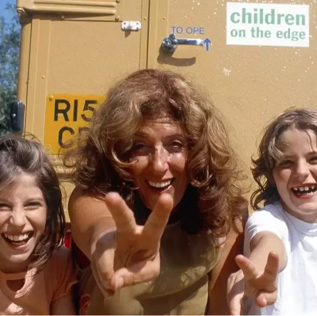 Anita Roddick in the early days of Children on the Edge doing a peace sign to the camera