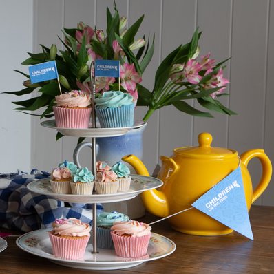yellow tea pot and a cake stand with cupcakes