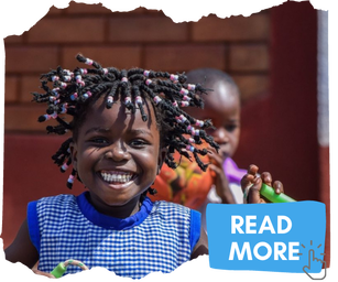Ugandan girl with blue gingham dress, braided hair with beads and a smile on her face. She is carrying a skipping rope and looking at the camera. Click this image to read more about the project.