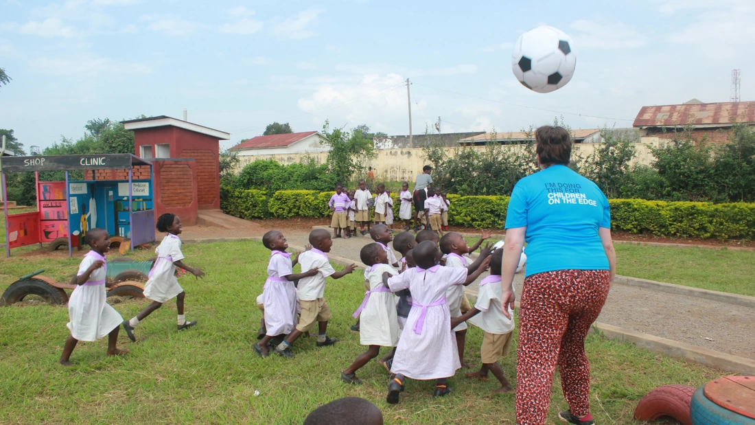Children in Uganda jumping and playing with a football