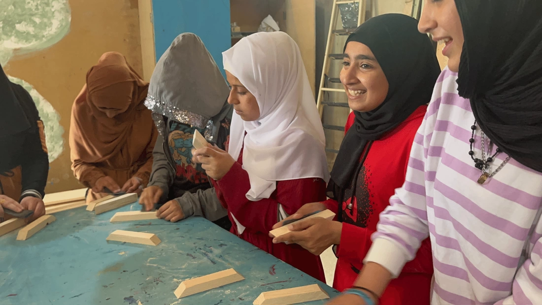 Syrian girls smiling in their carpentry class