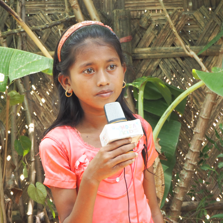 Student Jahan Tara filming for Moja kids holding a microphone