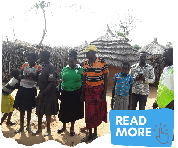 Group of villagers in Karamoja standing together outside homstead. 'Read More' clickable button