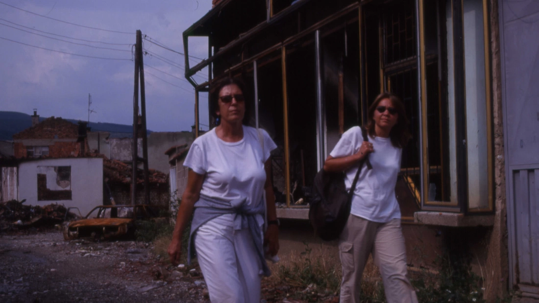 Dame Anita Roddick and Rachel Bentley walking together in Kosovo