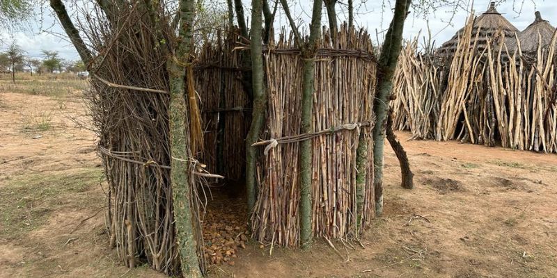 Latrine area made from sticks built outside a fenced homestead village in Karamoja