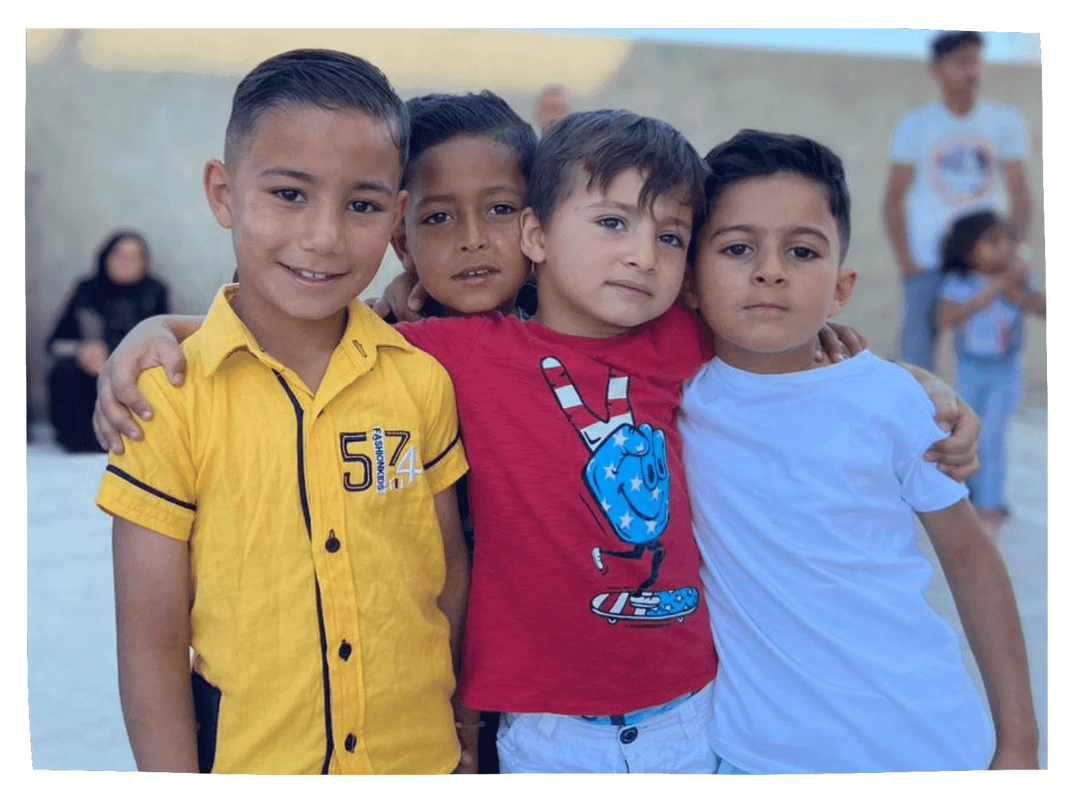 Four Syrian refugee boys stood together in playground