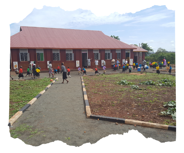 A brand new school building in Loco, Uganda. Children are playing outside wearing colourful tshirts. The sun is shining. 