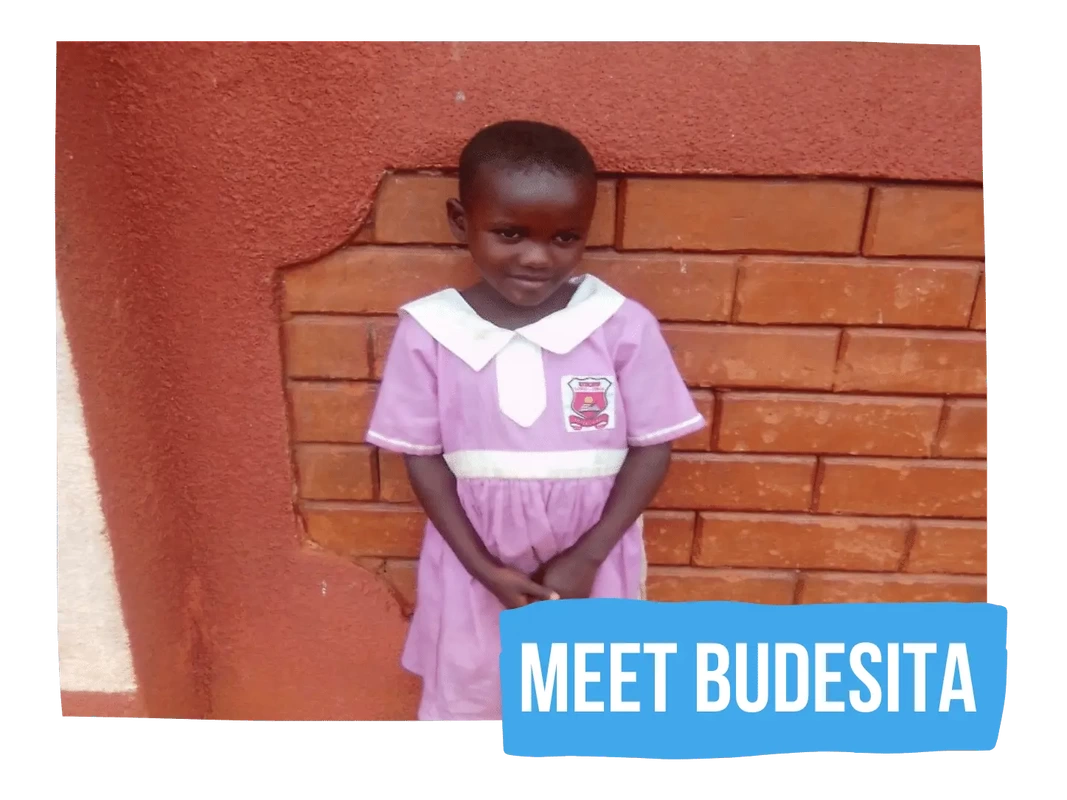 Budesita stood outside her preschool in a pink and white school dress