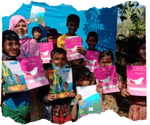 Students in Bangladesh at a Children on the Edge school holding up their new text books