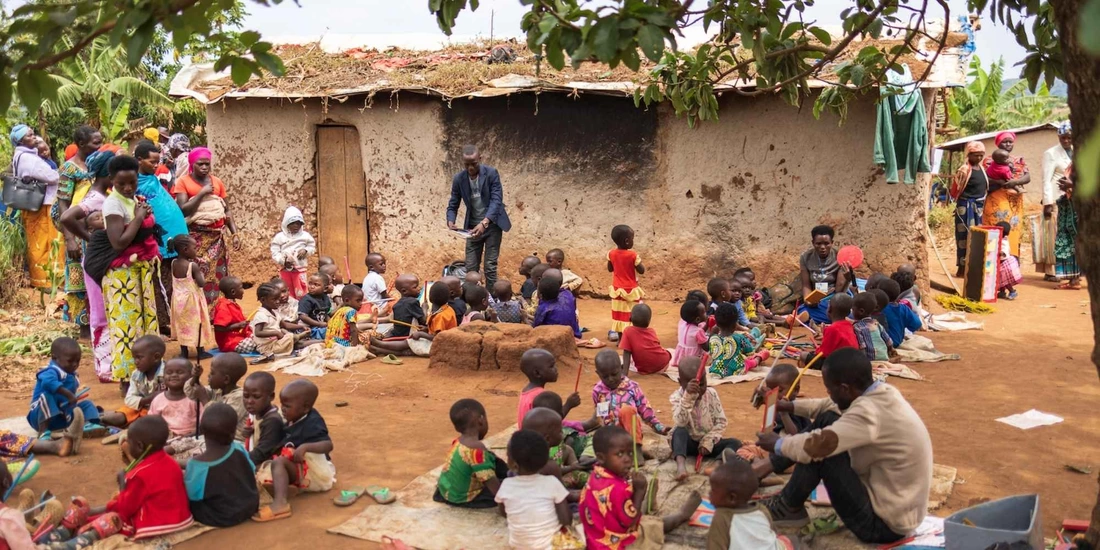 Young Congolese refugee children learning outside in small groups