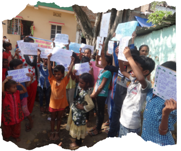 A large group of children in India are staging a demonstration about having a clean environment. They are all holding up signs. 
