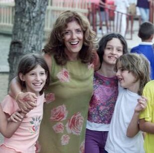 Dame Anita Roddick co-founder of Children on the Edge stood with her arms around three Romanian children in 1990. Anita is smiling, as are the children. You can click on the image to read more about our history.