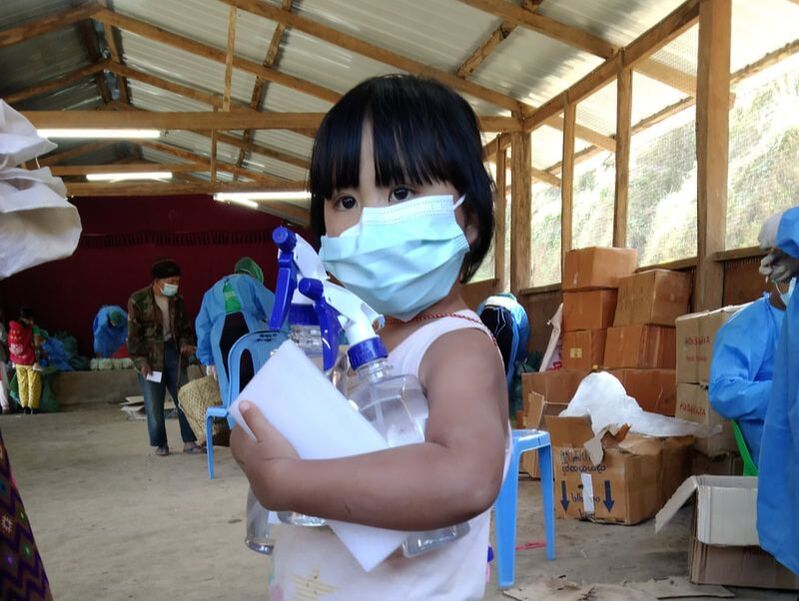 Kachin child holding hand sanitiser from the emergency food parcels