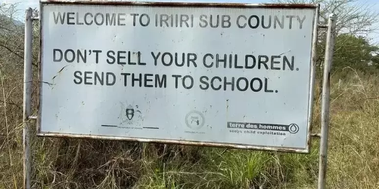Roadsign in Karamoja reads 'Don't sell your children, send them to school' 
