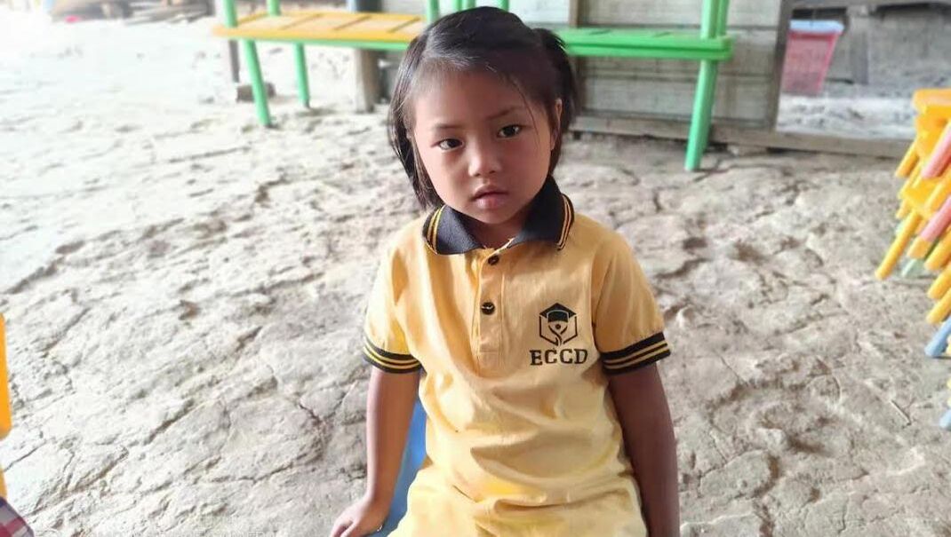 A young Kachin girl wearing a yellow tshirt at her preschool
