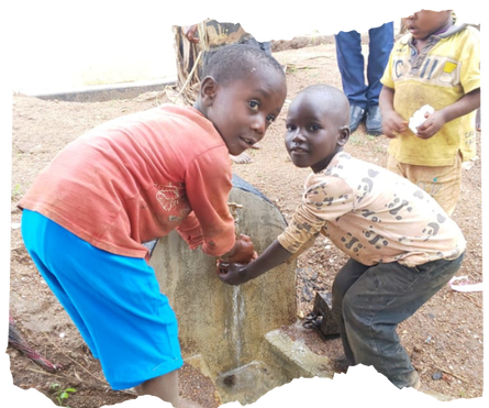 Two young Congolese refugees washing their hands a new tap installed near their classroom in Kyaka II