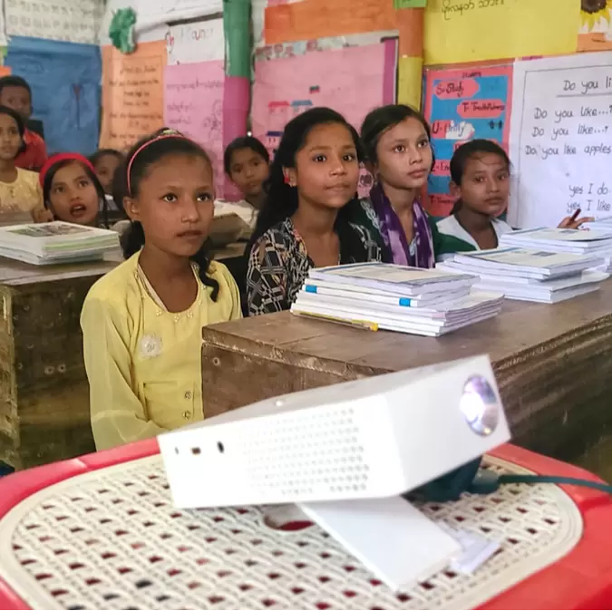 Rohingya children watching a digital lesson in Kutupalong refugee camp