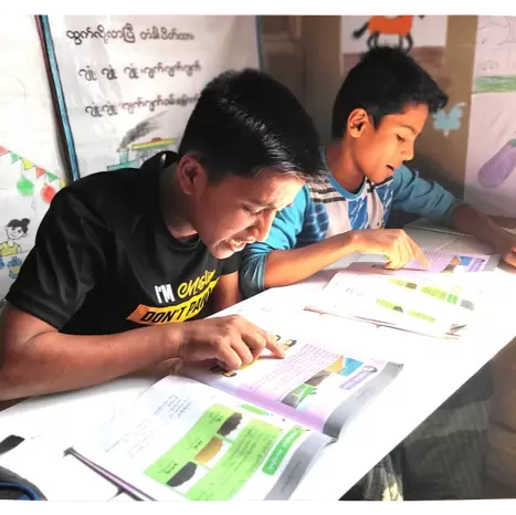 Two older boys studying in Bhasan Char classroom