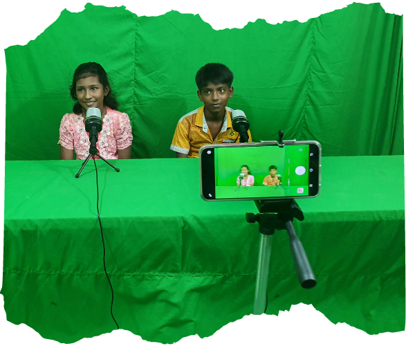 A boy and a girl in a green screen studio recording a message. 