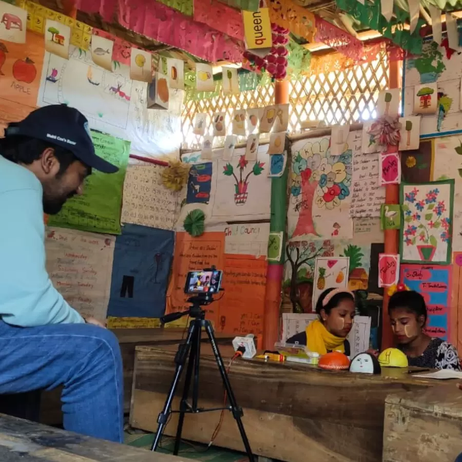 Two Rohingya children being filmed in their classroom in Bangladesh