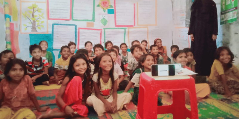 Children sat in their classroom watching a digital lesson projected from a small projector